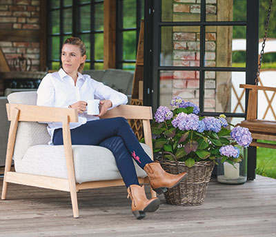 Springreiterein Janne Friederike Meyer-Zimmermann in ihrer selbstentworfenen Hose "Janne" auf der Terrasse