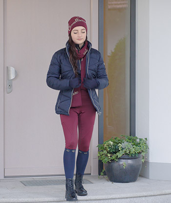 Frau trägt Covalliero Reitkleidung und LED Steppjacke