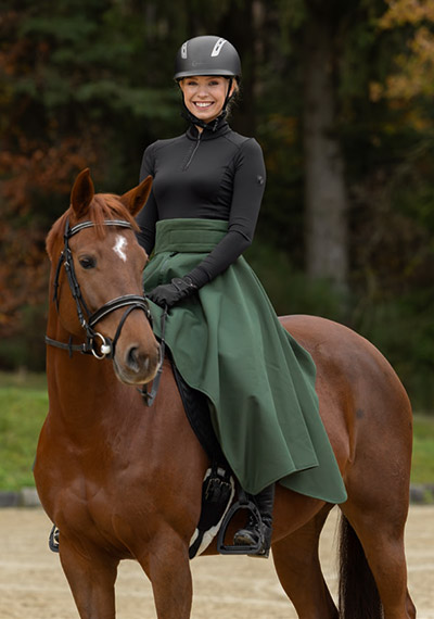Reiterinauf einem braunen Pferd im dunkelgrünen Thermorock der Covalliero Herbst Winter Trendkollektion