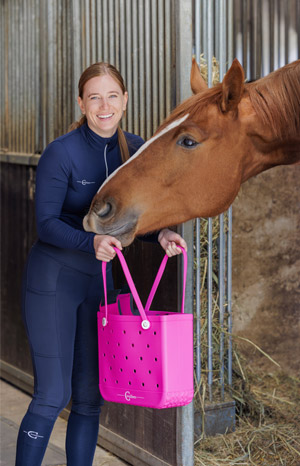 Reiterin im Stall mit Pferd und pinker Covalliero MultiBag